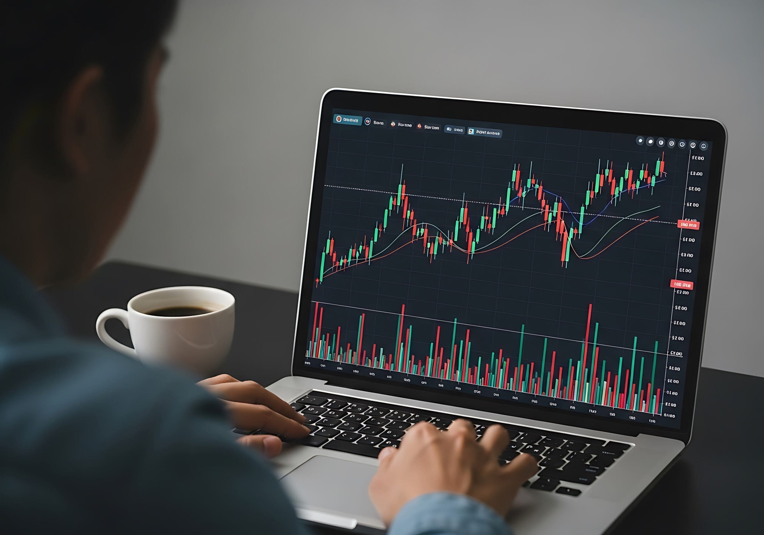 Over the shoulder view of a person analyzing stock market trading charts and graphs on a laptop.
